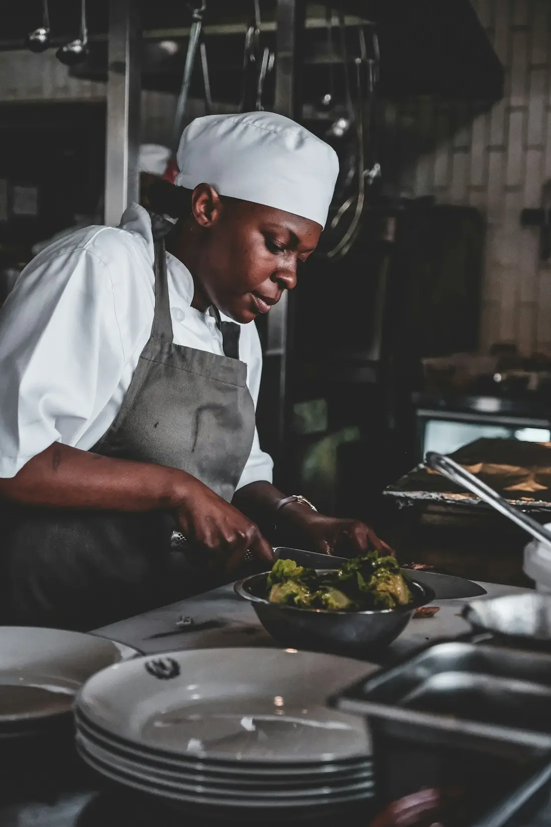 Cheffe dressant une assiette en cuisine professionnelle